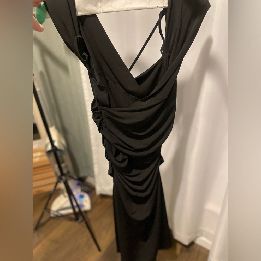 Strappy black dress. Polyester/spandex. Size Medium. Below knee. Worn twice.